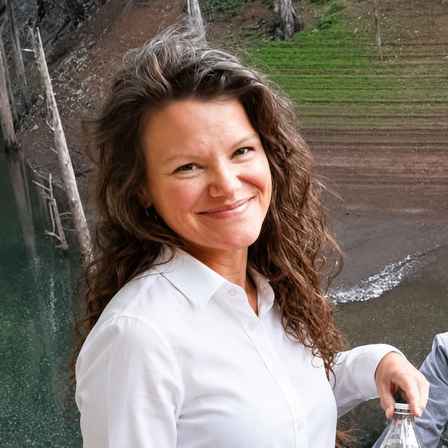 Rachel smiling outdoors by a lake